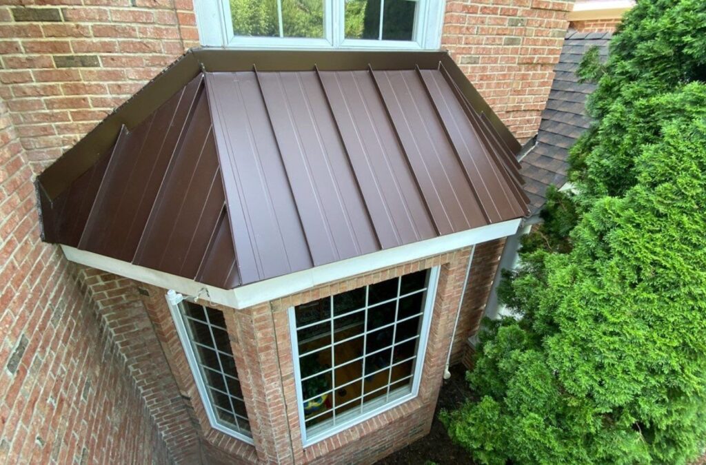 A Emerald Roofing and Siding technician working on metal panels in Suffern, NY, showcasing the advantages of local metal roofing solutions.