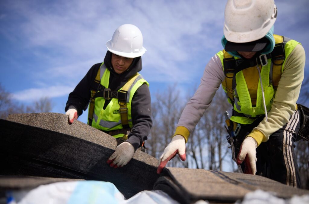 Emerald Roofing and Siding roofer completing roof installation in Montebello, NY, showing the value of hiring trusted local roofing professionals.