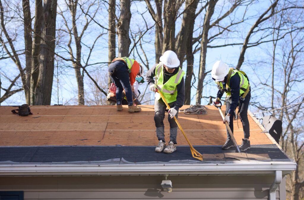 Crew member from Emerald Roofing and Siding working on roof installation in Valley Cottage, NY showing attention to detail and care.